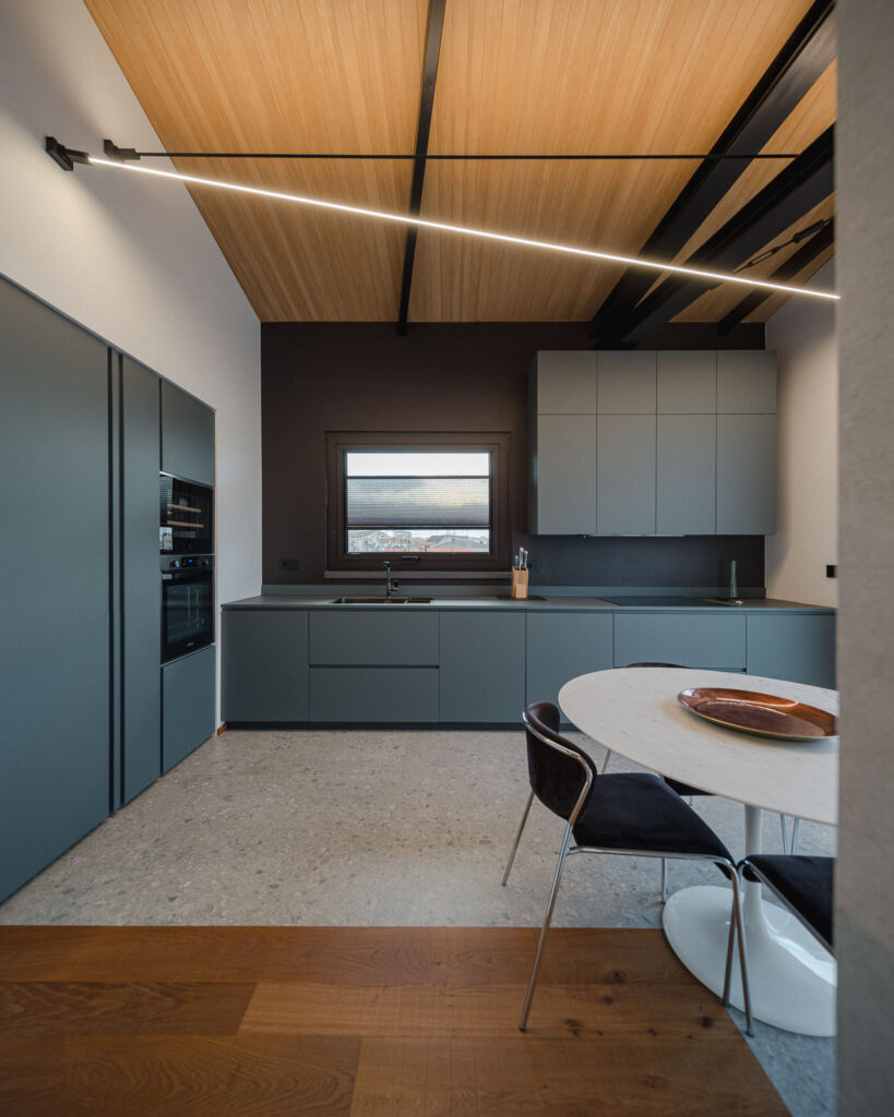 Cucina contemporanea grigio-verde con soffitto in legno e illuminazione lineare