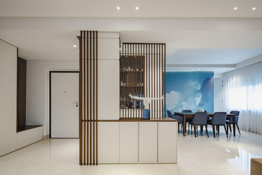 Ingresso contemporaneo con divisorio a listelli e zona pranzo con parete decorativa azzurra