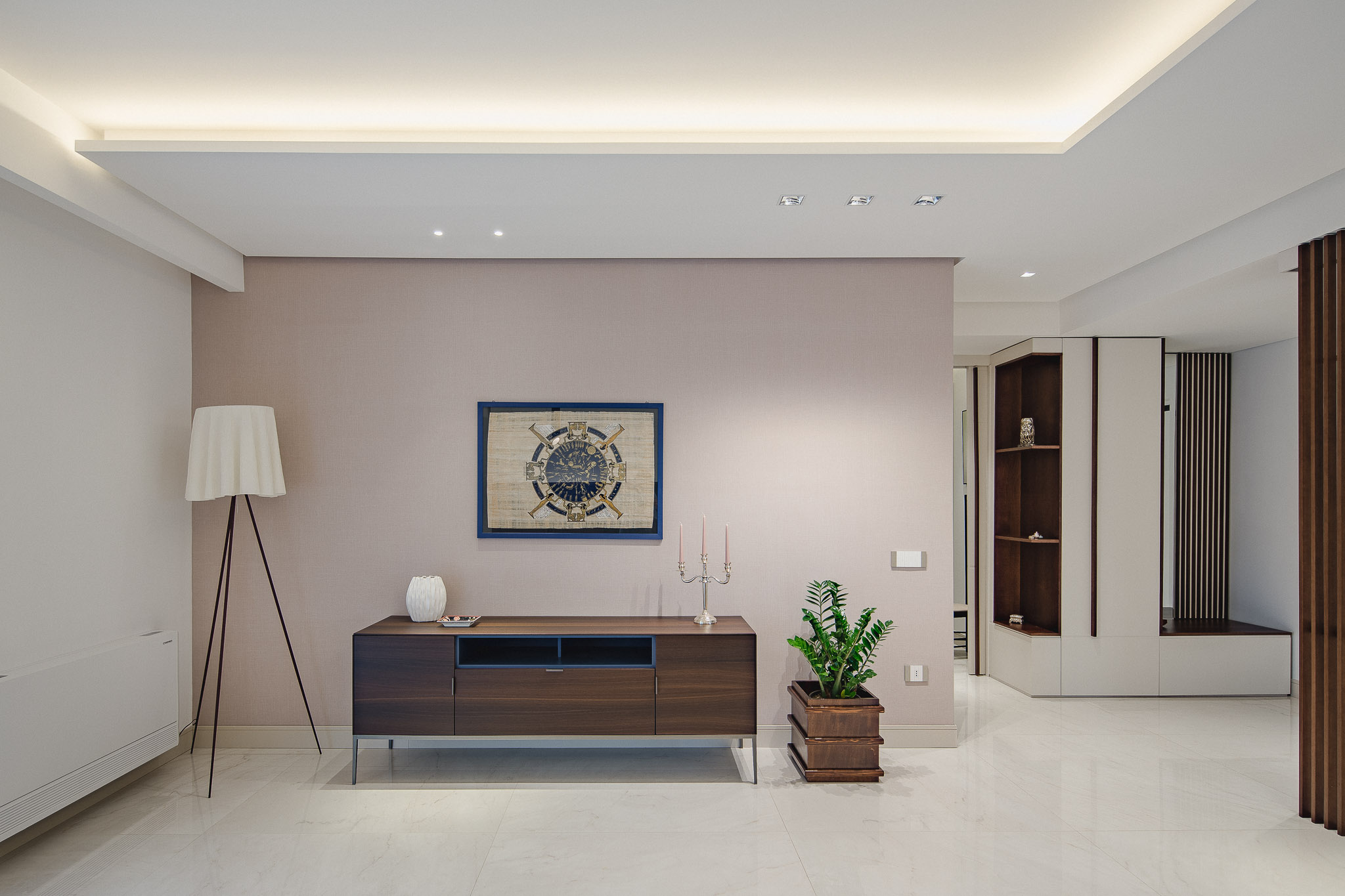 Parete rosa con madia e quadro accanto all’ingresso con armadiature realizzate su misura