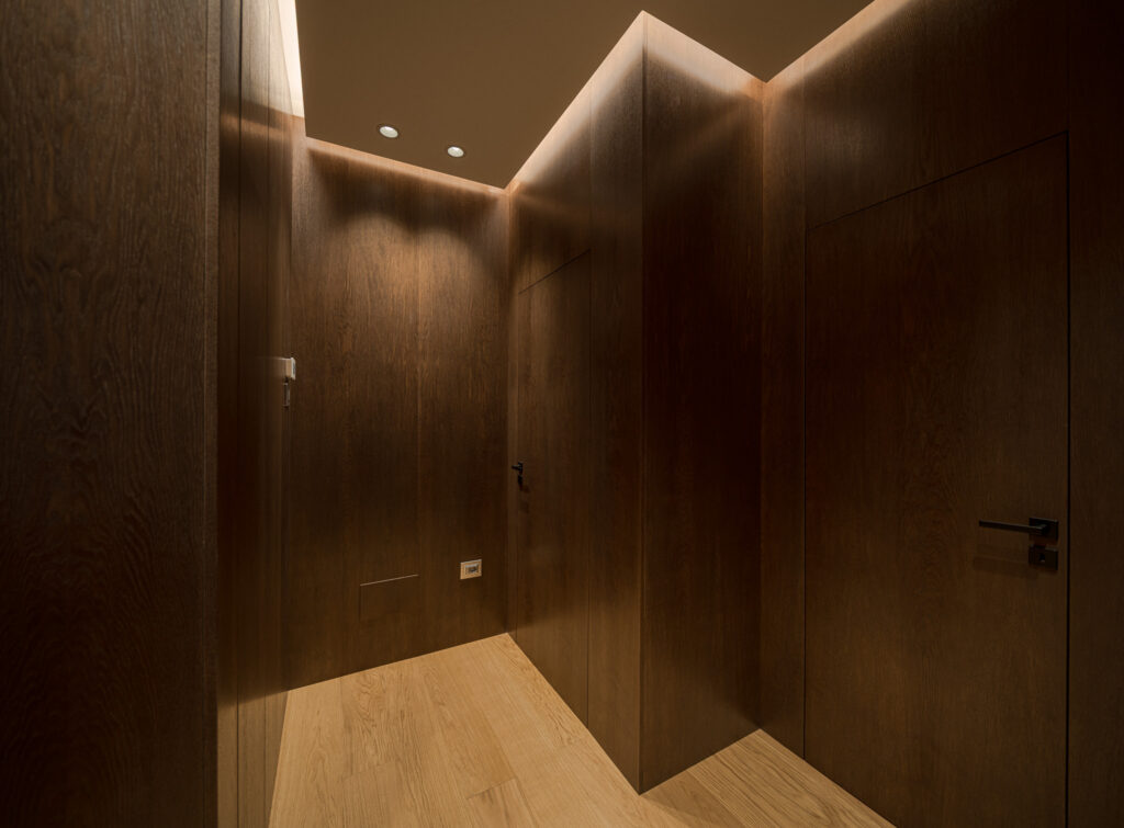 Disimpegno rivestito in legno con porte integrate e parquet