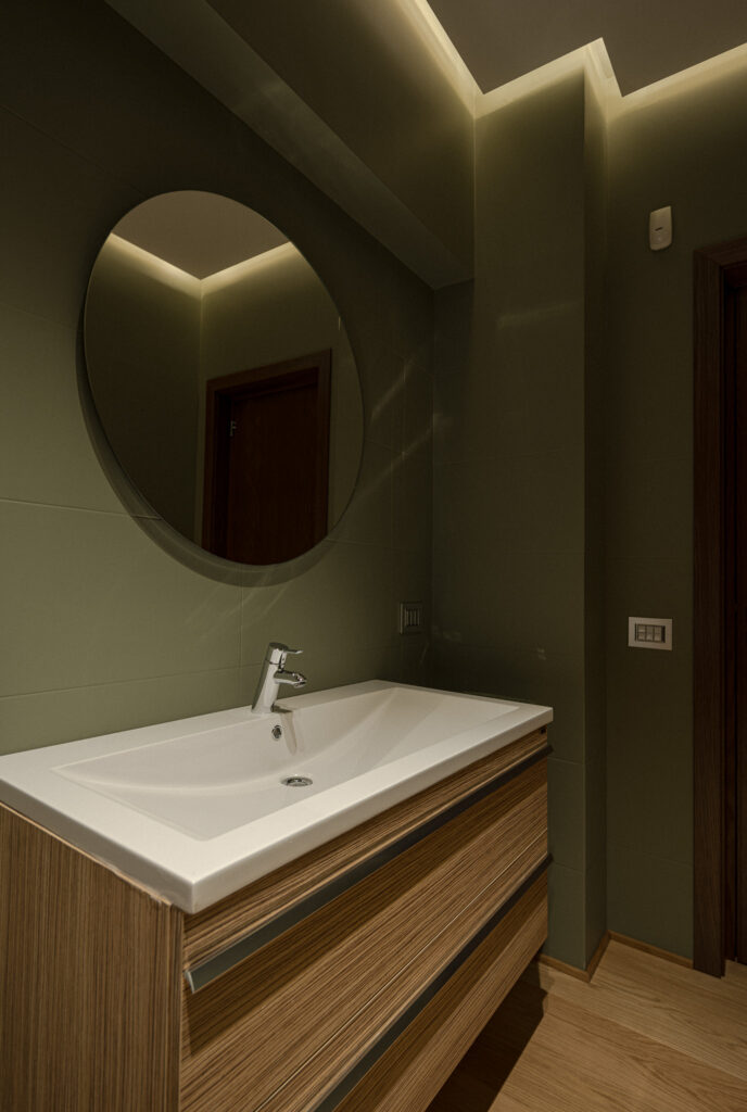 Mobile bagno in legno con lavabo bianco e specchio circolare