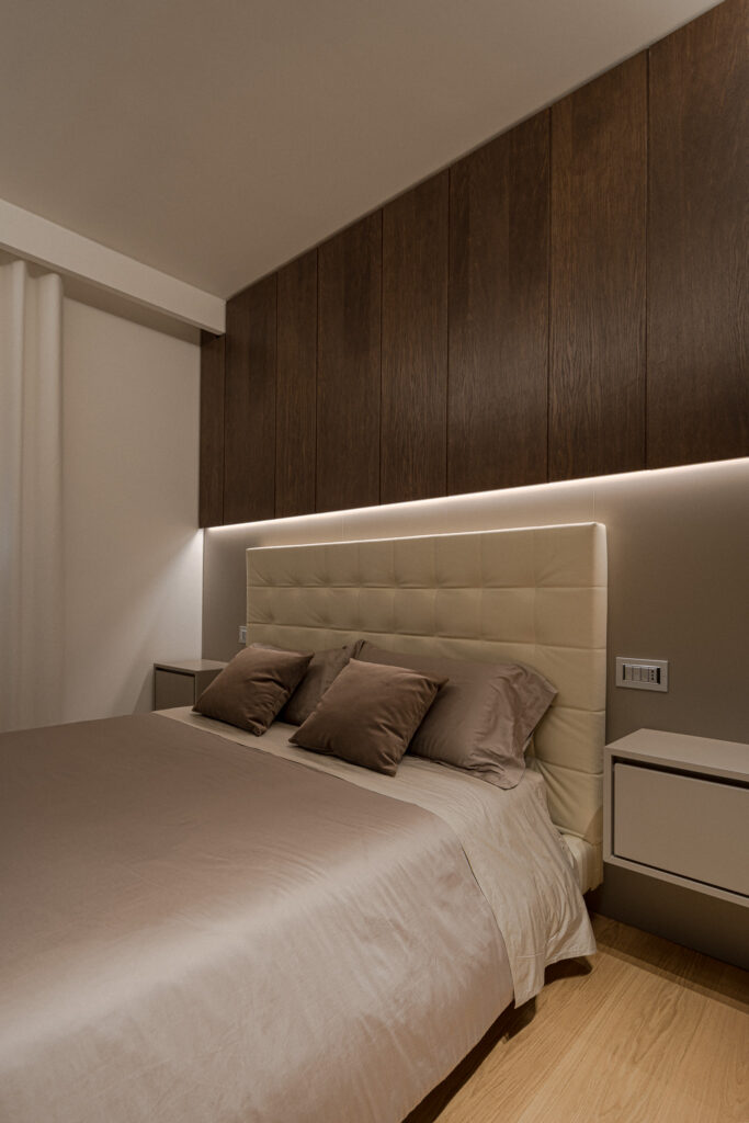 Letto matrimoniale con testiera imbottita e pensili in legno scuro