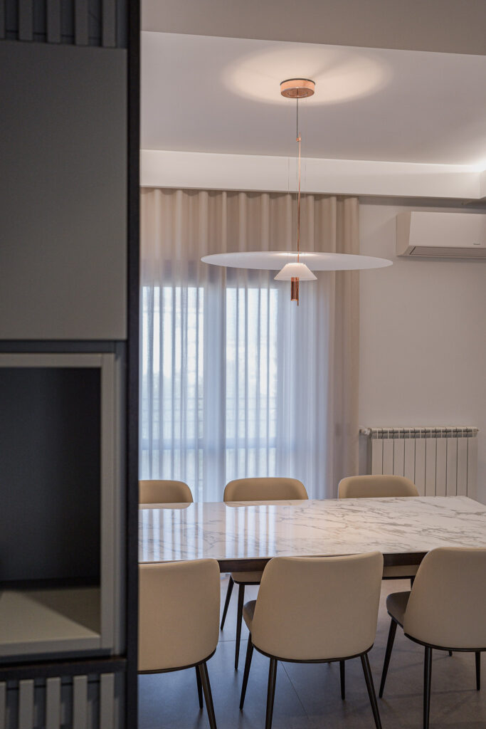 Tavolo da pranzo effetto marmo illuminato da lampada circolare