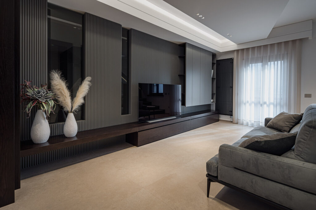 Parete TV con rivestimento a listelli, mobile basso e ampie finestre