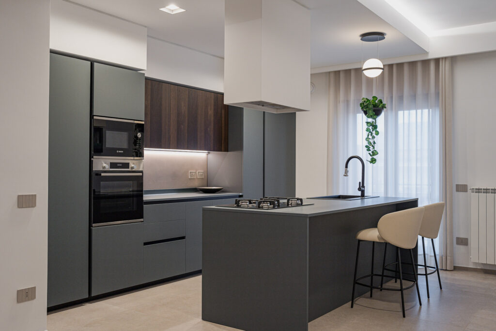 Cucina contemporanea grigia con isola, lavello nero e pensili in legno