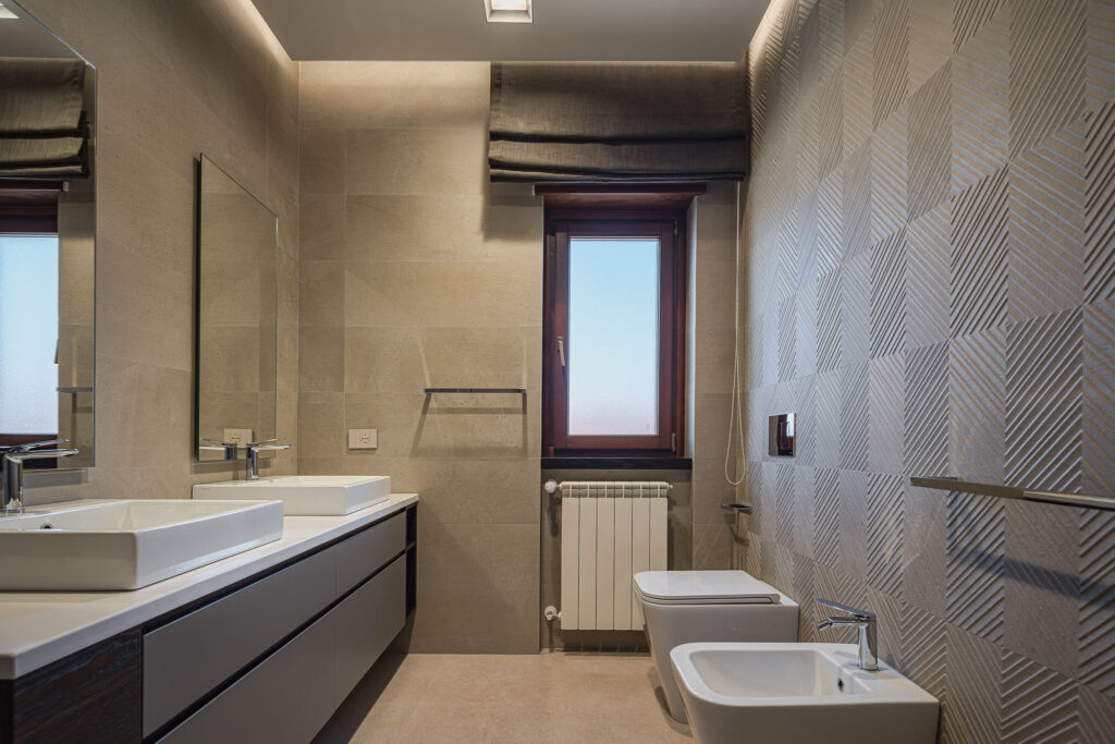WC e bidet accostati alla parete bagno con texture chevron