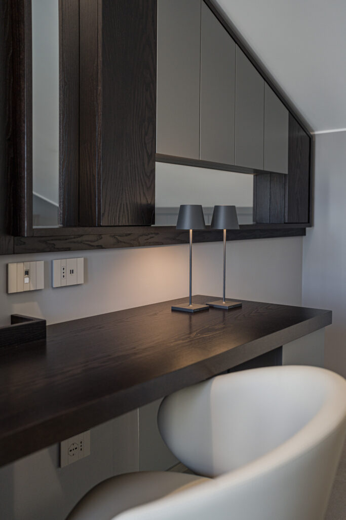 Piano scrittoio in legno con due lampade e specchio orizzontale
