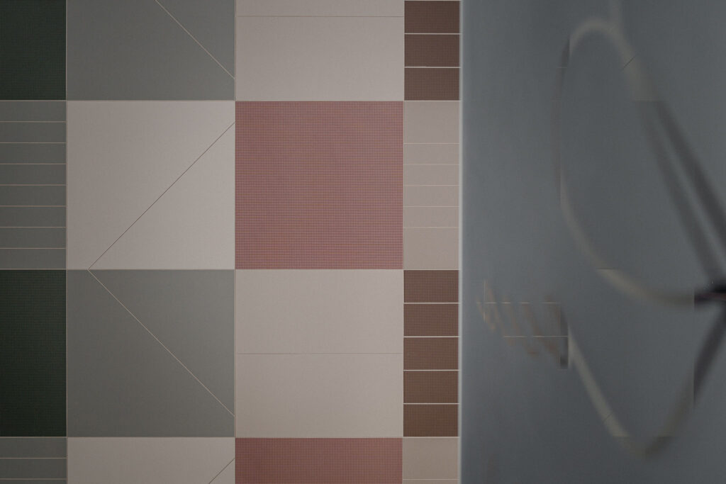 Rivestimento modulare colorato accanto alla quinta vetrata del salone