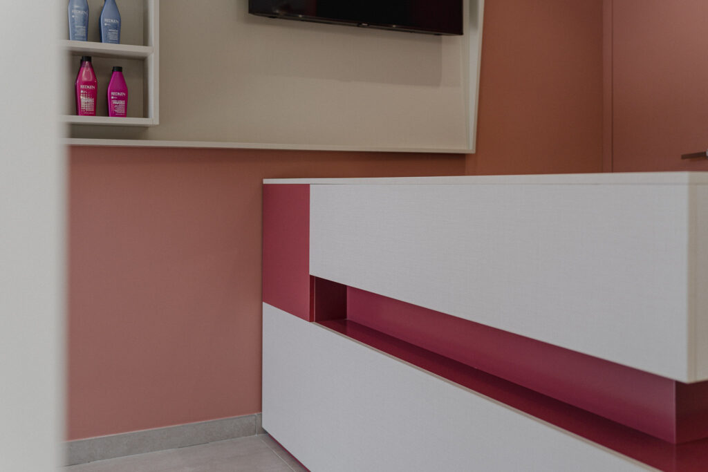 Banco bianco con vano rosa davanti alla parete coordinata