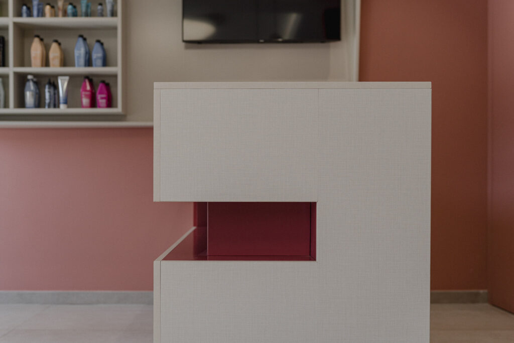 Fronte bianco del banco reception con apertura geometrica rosa