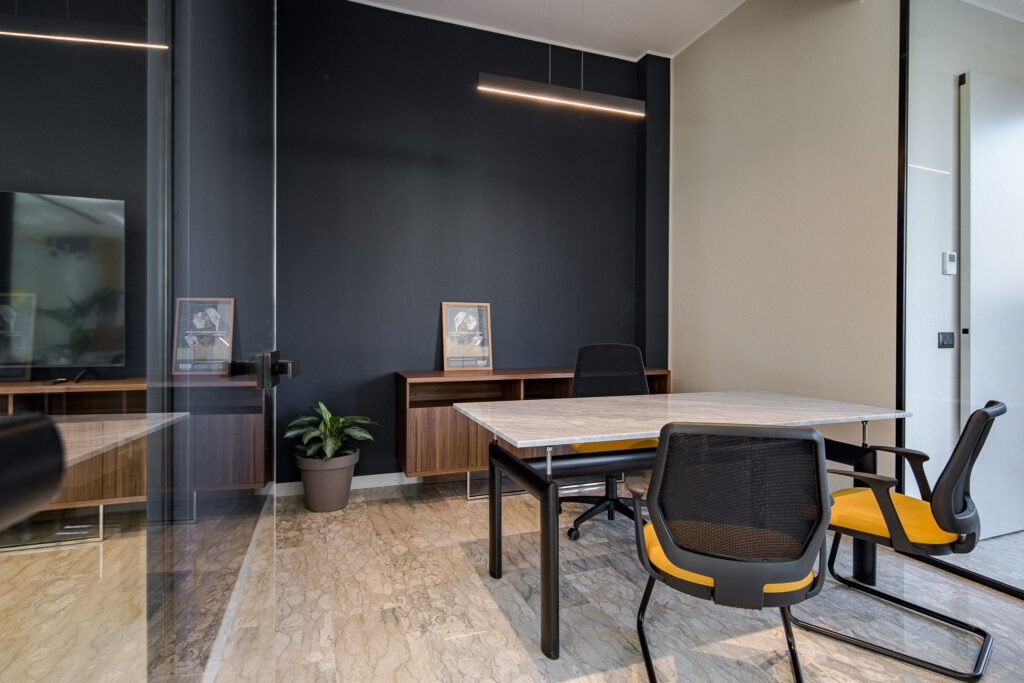 Area attesa in primo piano e postazioni di lavoro sullo sfondo