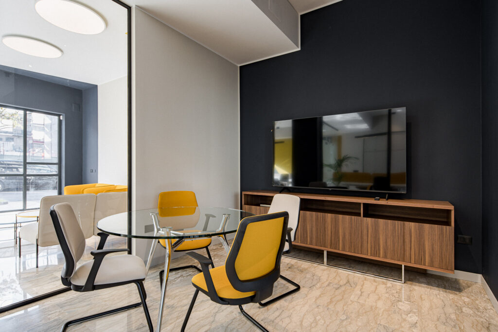 Ufficio con tavolo chiaro, mobile in legno e parete antracite