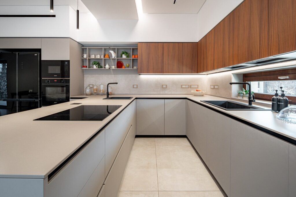 Cucina moderna grigia e in legno con penisola e piano cottura