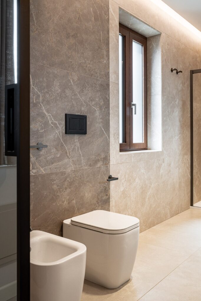 Sanitari bianchi davanti a parete rivestita in gres beige