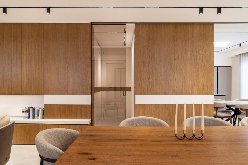 Parete in legno con fascia bianca e porta scorrevole in vetro