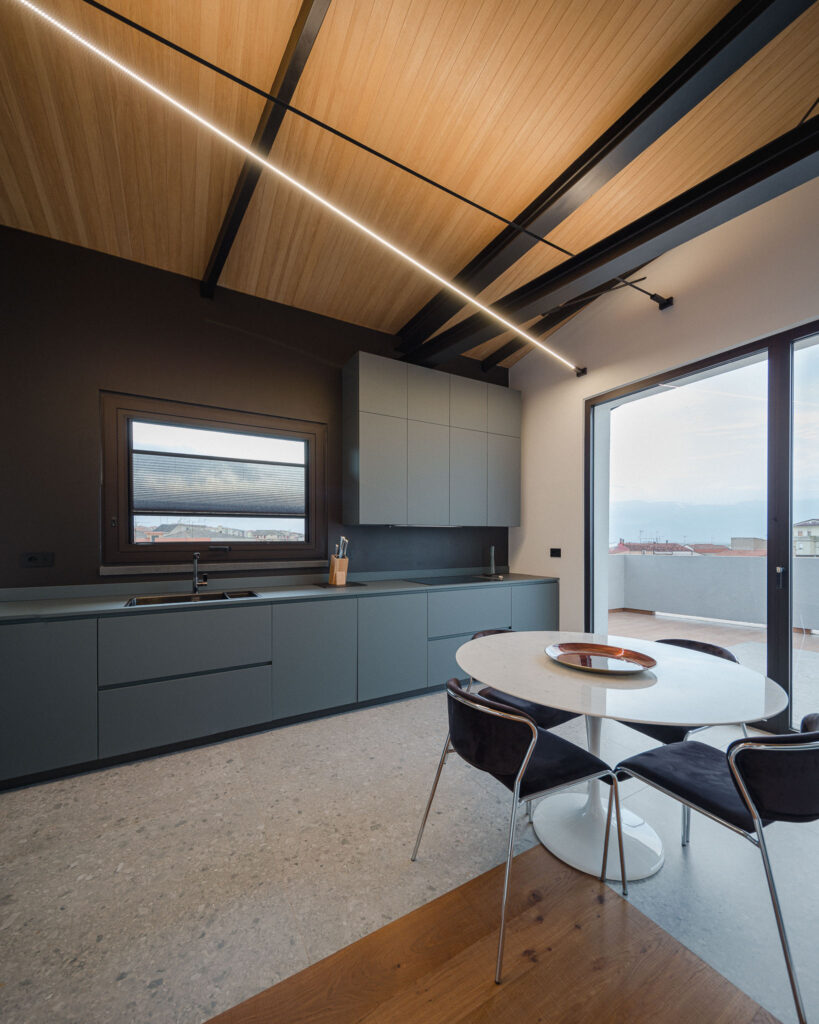 Cucina contemporanea con tavolo rotondo in marmo e vetrata affacciata sulla terrazza