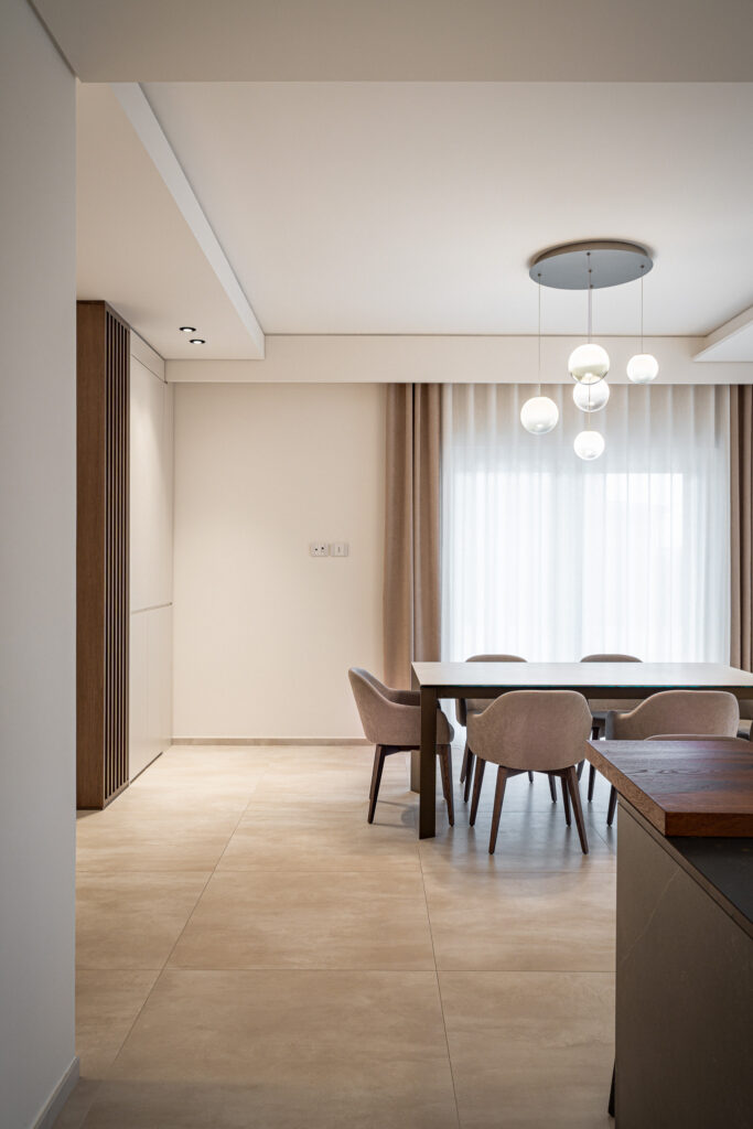 Sala da pranzo moderna con tavolo, sedute imbottite e lampadario a sfere